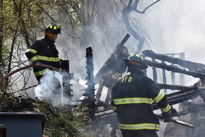 Rehoboth firefighters working a fire scene, one wearing a coat marked RFD.
