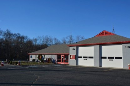 A Rehoboth Fire Department firehouse: a newer white and gray station with a red-trimmed peaked roof.